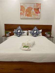 - un lit blanc avec 2 serviettes et des oreillers dans l'établissement The Nook by Garolu, à Castillejos