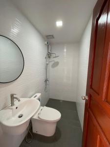 La salle de bains est pourvue d'un lavabo, de toilettes et d'un miroir. dans l'établissement The Nook by Garolu, à Castillejos