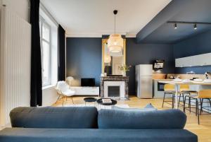 salon z niebieską kanapą i kuchnią w obiekcie - Le Loft de Doryan ! Gare- topappart nancy w Nancy