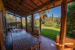 a porch with a table and chairs and a view at Affitti Brevi Toscana - A due passi dal Mare in Magliano in Toscana