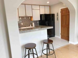 a kitchen with two stools and a counter with a sink at Steps To The BEST Beach . Surf . Spa . Main Street in Encinitas
