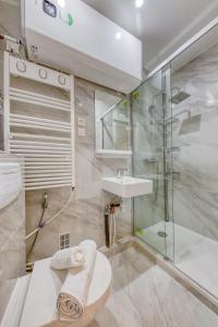 uma casa de banho com um chuveiro, um WC e um lavatório. em Les Bleus de Paris studio flat em Gentilly