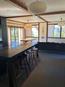 a large dining room with a large table and stools at NIKONOS III in Nozawa Onsen