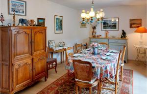 une salle à manger avec une table, des chaises et une commode dans l'établissement Awesome Home In Hennebont With Wifi, à Hennebont