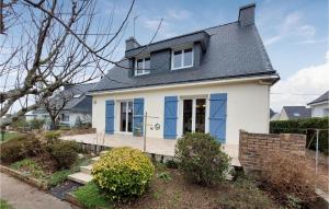 une maison blanche avec des fenêtres bleues et une terrasse couverte dans l'établissement Awesome Home In Hennebont With Wifi, à Hennebont