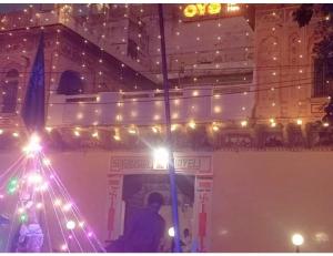 a man standing in front of a building with lights at Singhasan Haveli, Mandawa in Mandāwa