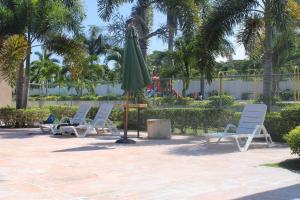 un gruppo di sedie e un ombrellone su un patio di Hidden Escape,pool,gated,gym,air-conditioned, a Mammee Bay