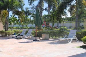 un grupo de sillas y una sombrilla en un patio en Hidden Escape,pool,gated,gym,air-conditioned,, en Mammee Bay