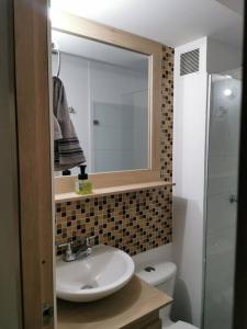 uma casa de banho com um lavatório, um espelho e um WC. em Duplicado Beautiful 25th floor apartment em Bello