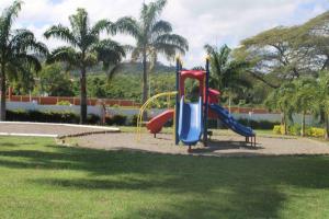 einen Spielplatz mit Rutsche in einem Park mit Palmen in der Unterkunft Hidden Escape,pool,gated,gym,air-conditioned, in Mammee Bay