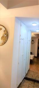 Habitación con pasillo, armario y reloj en la pared. en Barrio Norte hermoso apart privado en San Miguel de Tucumán