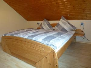 ein Holzbett in einem Zimmer mit Holzdecke in der Unterkunft Fewo Bleser in Cochem
