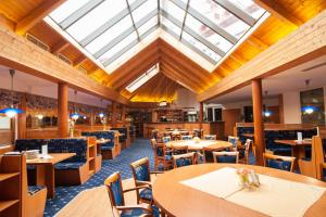 a restaurant with tables and chairs and a skylight at Sport-V-Hotel in Hrotovice