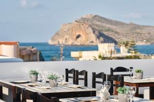 uma mesa com copos de vinho e vista para o oceano em Eva Suites & Apartments em Agia Marina Nea Kydonias
