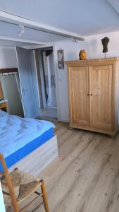 Schlafzimmer mit einem Bett und einem Holzschrank in der Unterkunft Mini Happy home in Reconvilier