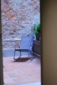 una sedia blu seduta di fronte a un muro di pietra di LuccaStay 99 a Lucca