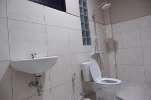 La salle de bains est pourvue de toilettes et d'un lavabo. dans l'établissement Gunza Bed and Breakfast by BIJAK, à Jatiluwih