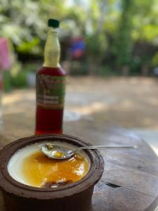 Una botella de salsa y una cuchara en una mesa. en Guruge villa en Hikkaduwa