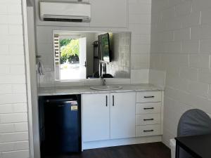 a kitchen with a sink and a mirror at Wattle Motel in Seymour
