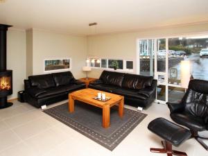 a living room with black leather furniture and a coffee table at Holiday Home Foreneset in Jelsa