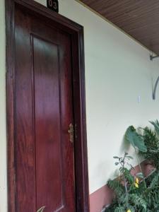 a wooden door with a plant next to it at Hoa Anh Đào Garden Hotel in Thuan An