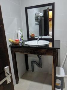 een badkamer met een wastafel en een spiegel bij Hoa Anh Đào Garden Hotel in Thuan An
