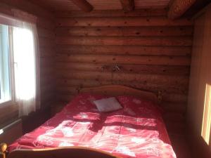 sypialnia z czerwonym łóżkiem w drewnianym domku w obiekcie Tuliranta w mieście Suonenjoki