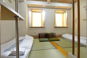 ein Zimmer mit zwei Etagenbetten und einem Tisch in der Unterkunft Juyoh Hotel in Tokio