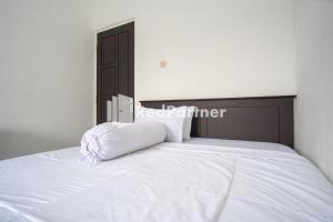 um quarto com uma cama com uma almofada branca em Katup Guest House Syariah Mitra RedDoorz em Yogyakarta