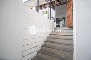 un escalier menant à une maison dans l'établissement Katup Guest House Syariah Mitra RedDoorz, à Yogyakarta