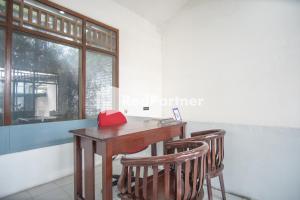 - une table et des chaises dans une chambre avec fenêtre dans l'établissement Katup Guest House Syariah Mitra RedDoorz, à Yogyakarta