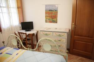 1 dormitorio con 1 cama y escritorio con TV en Su Livariu, en Siamaggiore