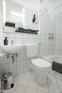 a white bathroom with a toilet and a sink at Swetis Passage in Pulheim