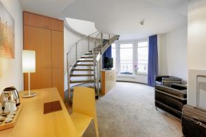 a living room with a spiral staircase in a room at Hotel Berlin Mitte by Campanile in Berlin