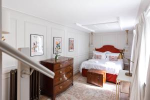 a bedroom with a bed and a wooden dresser at Brighton Brunswick Apartments in Brighton & Hove