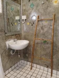 uma casa de banho com um lavatório e uma escada de toalha em Vlodge House em Chiang Mai