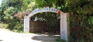 ein Torbogen mit einem Schild, auf dem das Dorf steht in der Unterkunft Boraha Village Ecolodge in Sainte Marie