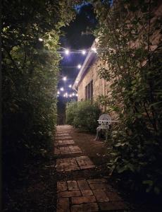 an alleyway with a bench and lights at night at DAYLESFORD Frog Hollow Estate THE BARN - Wanting a different experience - Stay in the Barn - Table Tennis Table - Cinema Projector - Bar - Wood Fireplace - 3 QUEEN BEDS - A fun place for everyone in Daylesford