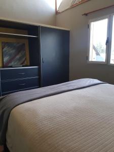 1 dormitorio con 1 cama con tocador y ventana en Casa Sol en San Martín de los Andes