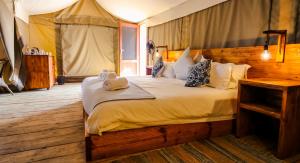ein Schlafzimmer mit einem großen Bett in einem Zelt in der Unterkunft Ondudu Safari Lodge in Omaruru