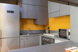 a kitchen with stainless steel appliances and yellow walls at Castello Duomo Milano in Milan