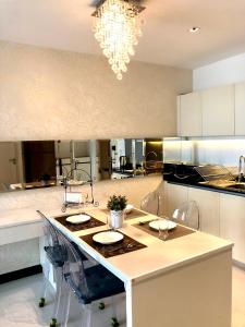 a kitchen with a island with chairs and a chandelier at Asoke Bts Mrt Bangkok New Luxury Room in Bangkok