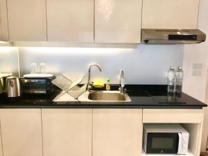 a kitchen with a sink and a microwave at Asoke Bts Mrt Bangkok New Luxury Room in Bangkok