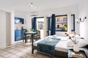 a bedroom with a bed and a kitchen with a table at Eva Suites & Apartments in Agia Marina Nea Kydonias