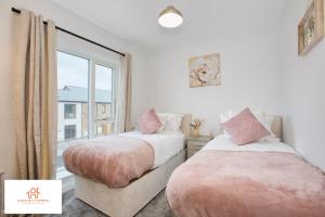 dwa łóżka w pokoju z oknem w obiekcie St Ives Bay - Immaculate Brand New 3Bed - Free Parking - Beach - WiFi w mieście Hayle