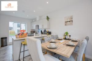 海爾的住宿－St Ives Bay - Immaculate Brand New 3Bed - Free Parking - Beach - WiFi，厨房以及带木桌和椅子的用餐室。