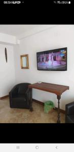 sala de estar con mesa y TV de pantalla plana en Casa Royal Haveli, en Costinesti