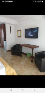 sala de estar con mesa y TV en la pared en Casa Royal Haveli, en Costinesti