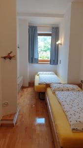 twee bedden in een kamer met een raam bij Ferienwohnungen Koflerhof in Castelrotto