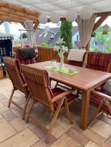 una mesa de madera y sillas en un patio en Ferienwohnungen Koch, en Marburg an der Lahn